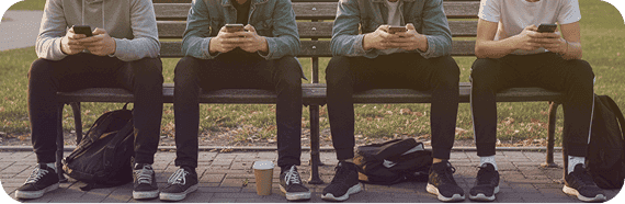 A row of people on a bench, each absorbed in their phone
